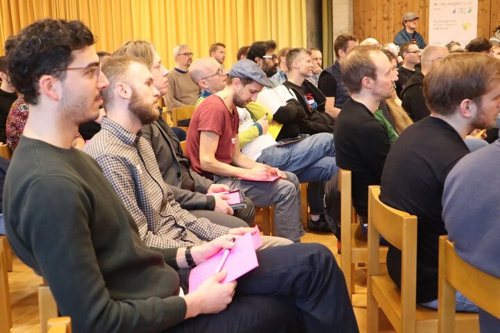 Attendees seated in the conference hall taking notes during a session